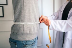A physician and adult patient discussing a personalized weight loss plan in a medical office.