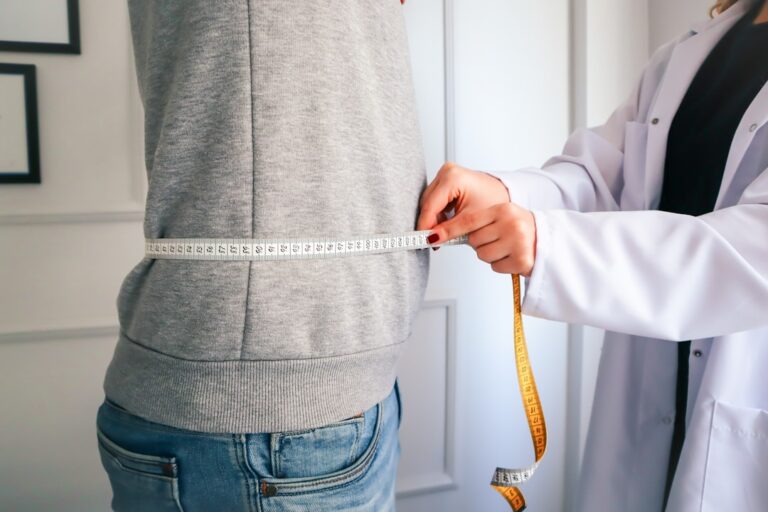 A physician and adult patient discussing a personalized weight loss plan in a medical office.